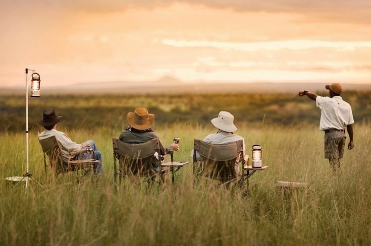 Private group at a bush sundowner stop with their guide at golden hour